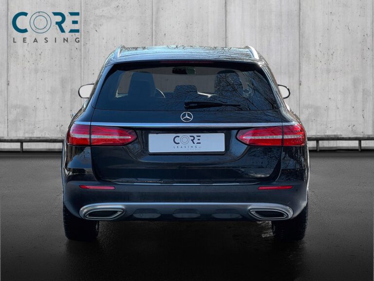 Sortmetal Mercedes E400 d All-Terrain aut. 4Matic fra 2018 parkeret foran en betonmur. CORE Leasing A/S er eksperter i Mercedes leasing.