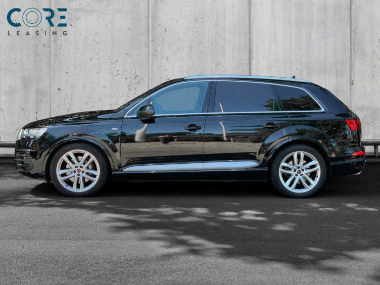 Sortmetal Audi Q7 TDi 272 S-line quattro Tiptr. 7prs fra 2016 parkeret foran en betonmur. CORE Leasing A/S er eksperter i Audi leasing.