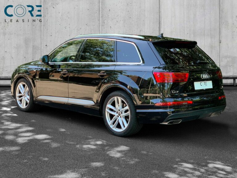 Sortmetal Audi Q7 TDi 272 S-line quattro Tiptr. 7prs fra 2016 parkeret foran en betonmur. CORE Leasing A/S er eksperter i Audi leasing.