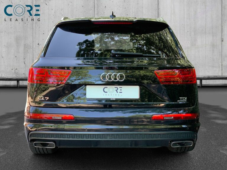 Sortmetal Audi Q7 TDi 272 S-line quattro Tiptr. 7prs fra 2016 parkeret foran en betonmur. CORE Leasing A/S er eksperter i Audi leasing.