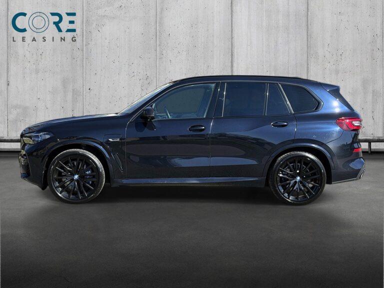 Sortmetal BMW X5 xDrive45e M-Sport aut. fra 2022 parkeret foran en betonmur. CORE Leasing A/S er eksperter i BMW leasing.
