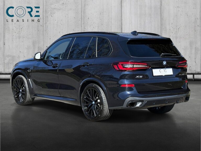 Sortmetal BMW X5 xDrive45e M-Sport aut. fra 2022 parkeret foran en betonmur. CORE Leasing A/S er eksperter i BMW leasing.
