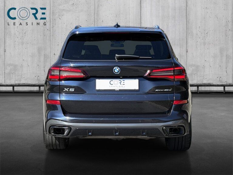 Sortmetal BMW X5 xDrive45e M-Sport aut. fra 2022 parkeret foran en betonmur. CORE Leasing A/S er eksperter i BMW leasing.