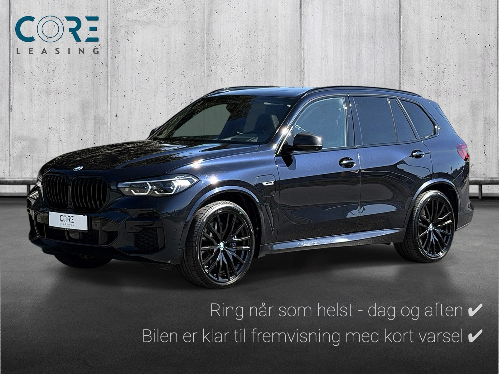 Sortmetal BMW X5 xDrive45e M-Sport aut. fra 2022 parkeret foran en betonmur. CORE Leasing A/S er eksperter i BMW leasing.