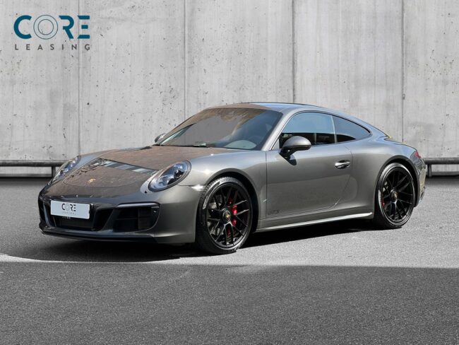 Gråmetal Porsche 911 Carrera 4 GTS Coupé PDK fra 2018 parkeret foran en betonmur. CORE Leasing A/S er eksperter i Porsche leasing.