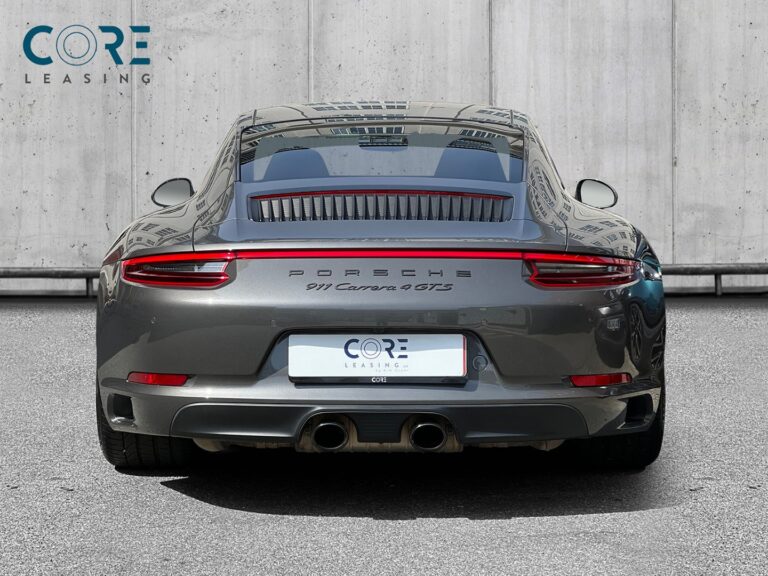 Gråmetal Porsche 911 Carrera 4 GTS Coupé PDK fra 2018 parkeret foran en betonmur. CORE Leasing A/S er eksperter i Porsche leasing.
