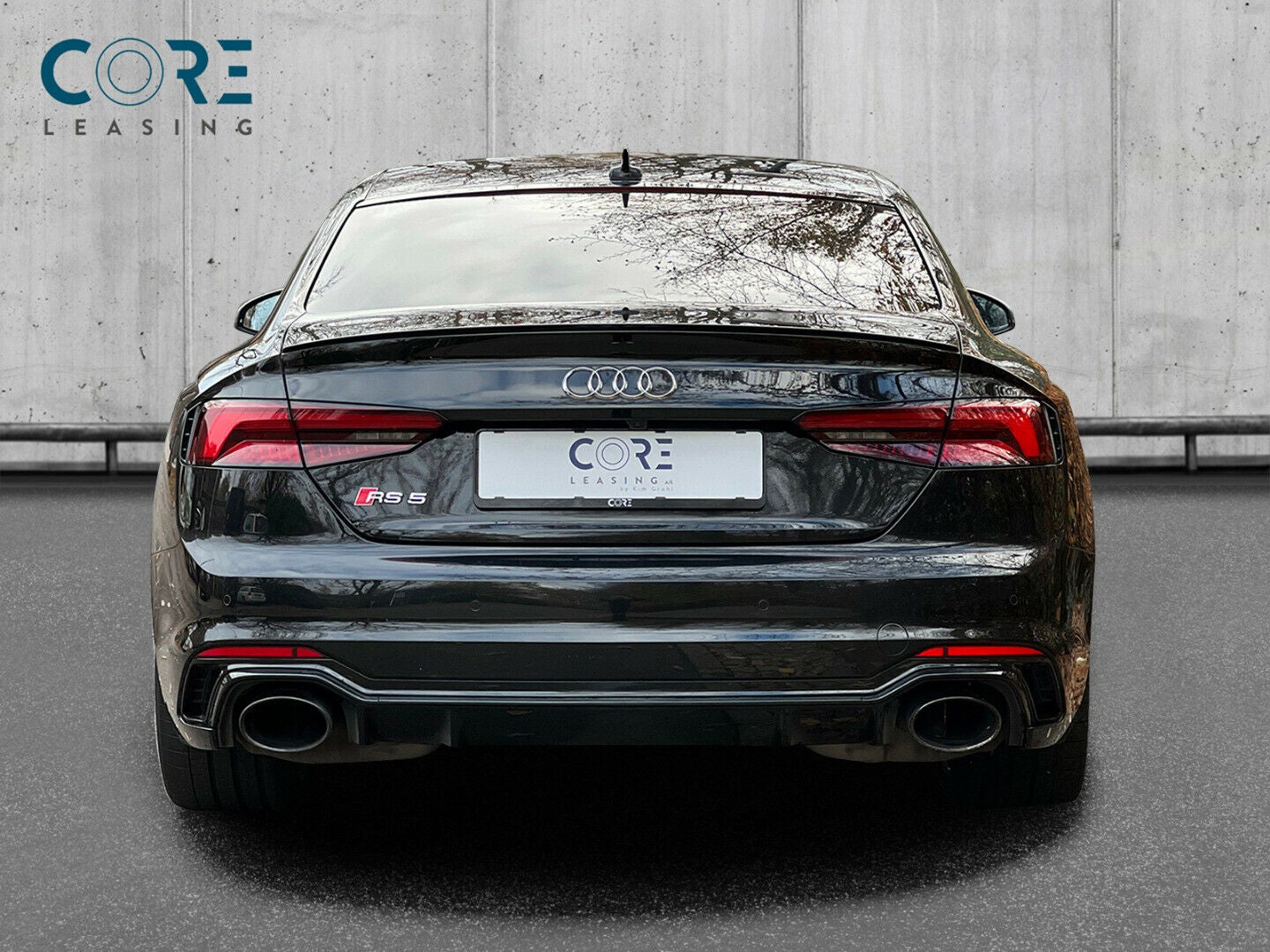 Sortmetal Audi RS5 TFSi Coupé quattro Tiptr. fra 2017 parkeret foran en betonmur. CORE Leasing A/S er eksperter i Audi leasing.
