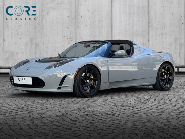 Gråmetal Tesla Roadster  fra 2010 parkeret foran en betonmur. CORE Leasing A/S er eksperter i Tesla leasing.