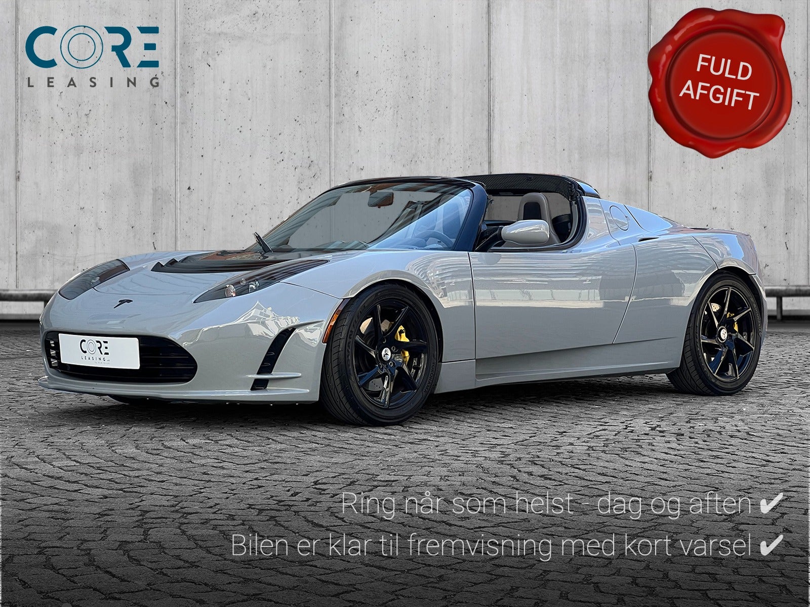 Gråmetal Tesla Roadster  fra 2010 parkeret foran en betonmur. CORE Leasing A/S er eksperter i Tesla leasing.