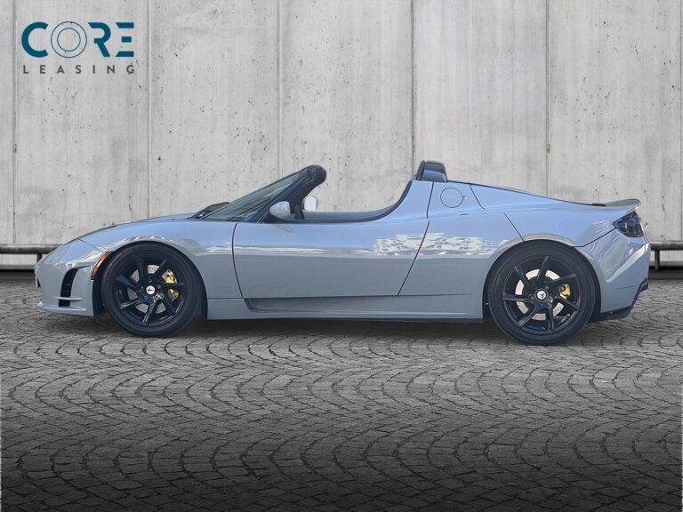 Gråmetal Tesla Roadster  fra 2010 parkeret foran en betonmur. CORE Leasing A/S er eksperter i Tesla leasing.