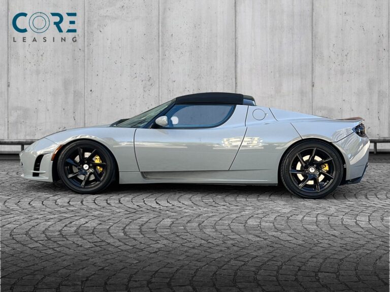 Gråmetal Tesla Roadster  fra 2010 parkeret foran en betonmur. CORE Leasing A/S er eksperter i Tesla leasing.