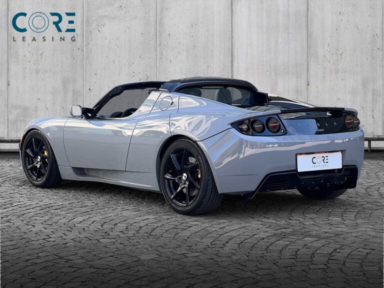 Gråmetal Tesla Roadster  fra 2010 parkeret foran en betonmur. CORE Leasing A/S er eksperter i Tesla leasing.