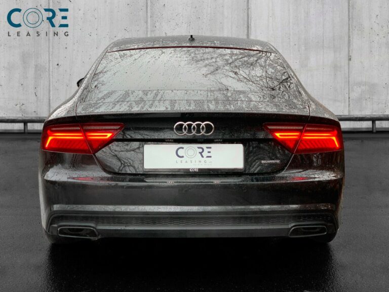Sortmetal Audi A7 TDi 326 Sportback quattro Tiptr. fra 2017 parkeret foran en betonmur. CORE Leasing A/S er eksperter i Audi leasing.