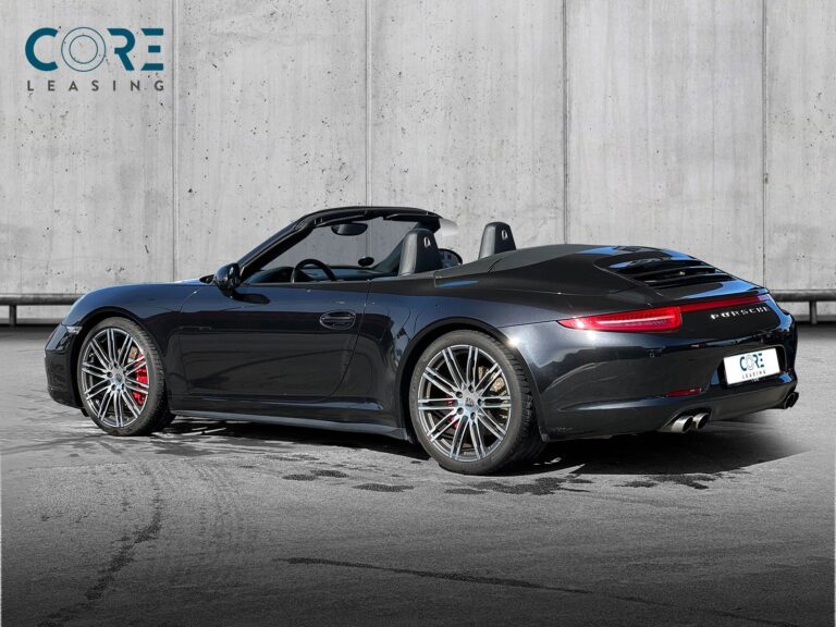 Sortmetal Porsche 911 Carrera 4S Cabriolet PDK fra 2013 parkeret foran en betonmur. CORE Leasing A/S er eksperter i Porsche leasing.