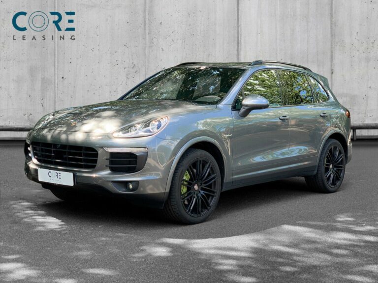 Gråmetal Porsche Cayenne S E-Hybrid Tiptr. fra 2016 parkeret foran en betonmur. CORE Leasing A/S er eksperter i Porsche leasing.