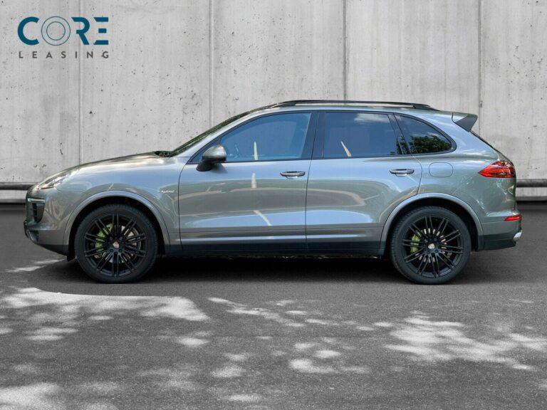 Gråmetal Porsche Cayenne S E-Hybrid Tiptr. fra 2016 parkeret foran en betonmur. CORE Leasing A/S er eksperter i Porsche leasing.