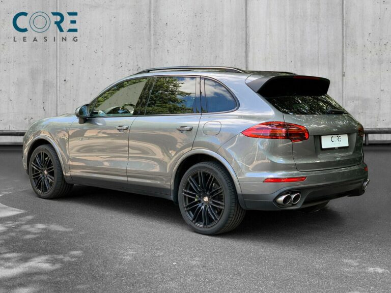 Gråmetal Porsche Cayenne S E-Hybrid Tiptr. fra 2016 parkeret foran en betonmur. CORE Leasing A/S er eksperter i Porsche leasing.