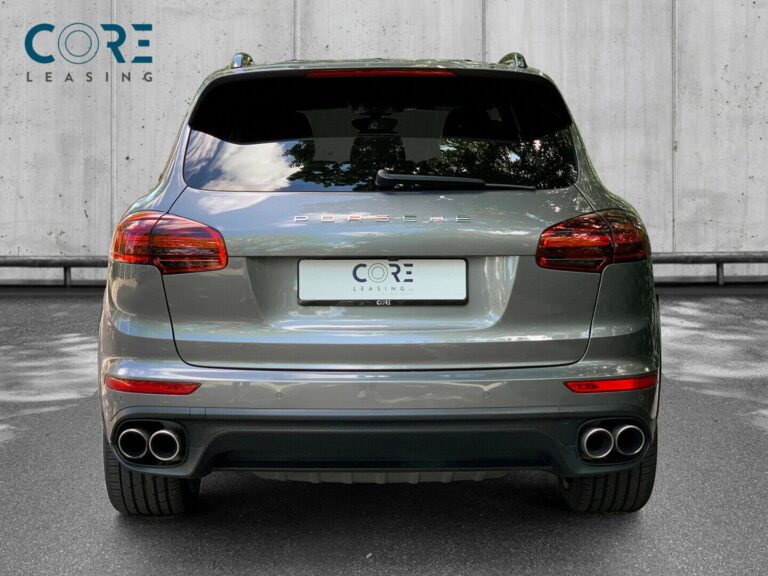 Gråmetal Porsche Cayenne S E-Hybrid Tiptr. fra 2016 parkeret foran en betonmur. CORE Leasing A/S er eksperter i Porsche leasing.