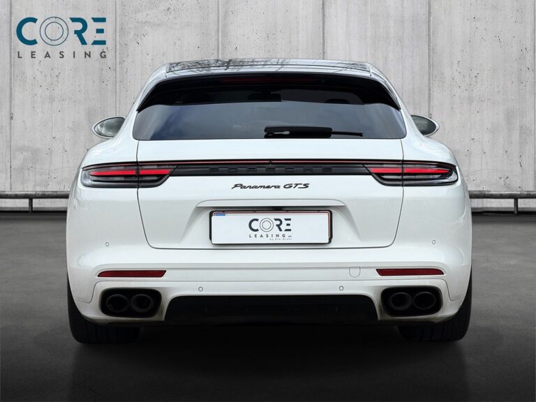 Hvid Porsche Panamera GTS Sport Turismo PDK fra 2020 parkeret foran en betonmur. CORE Leasing A/S er eksperter i Porsche leasing.