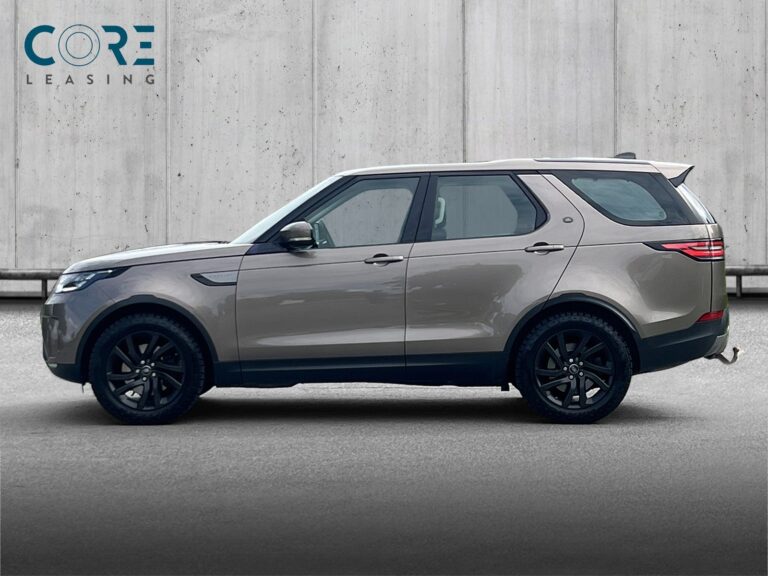 Brunmetal Land Rover Discovery 5 TD6 SE aut. fra 2017 parkeret foran en betonmur. CORE Leasing A/S er eksperter i Land Rover leasing.