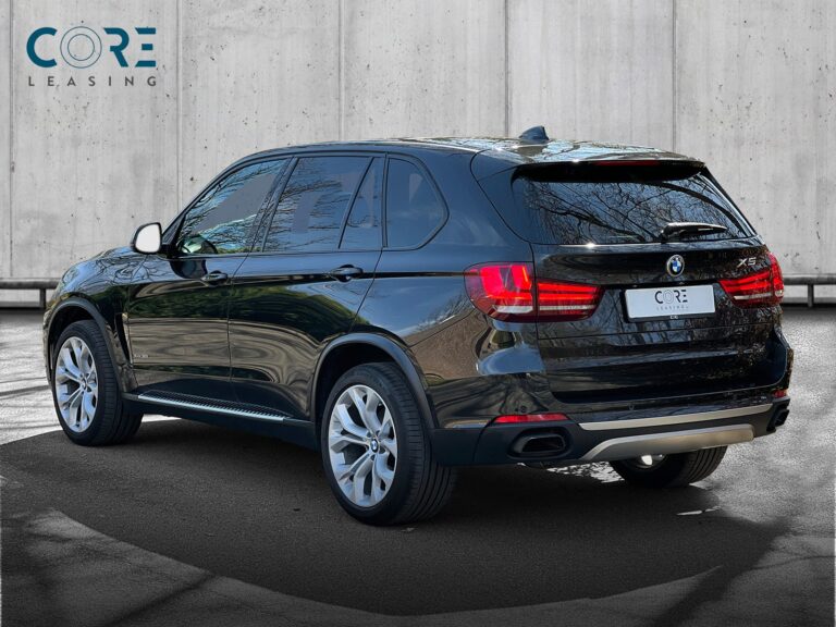 Sortmetal BMW X5 xDrive50i aut. fra 2015 parkeret foran en betonmur. CORE Leasing A/S er eksperter i BMW leasing.