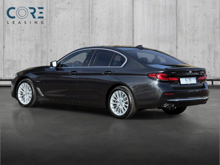 Gråmetal BMW 545e Luxury Line xDrive aut. fra 2021 parkeret foran en betonmur. CORE Leasing A/S er eksperter i BMW leasing.