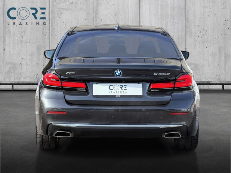 Gråmetal BMW 545e Luxury Line xDrive aut. fra 2021 parkeret foran en betonmur. CORE Leasing A/S er eksperter i BMW leasing.