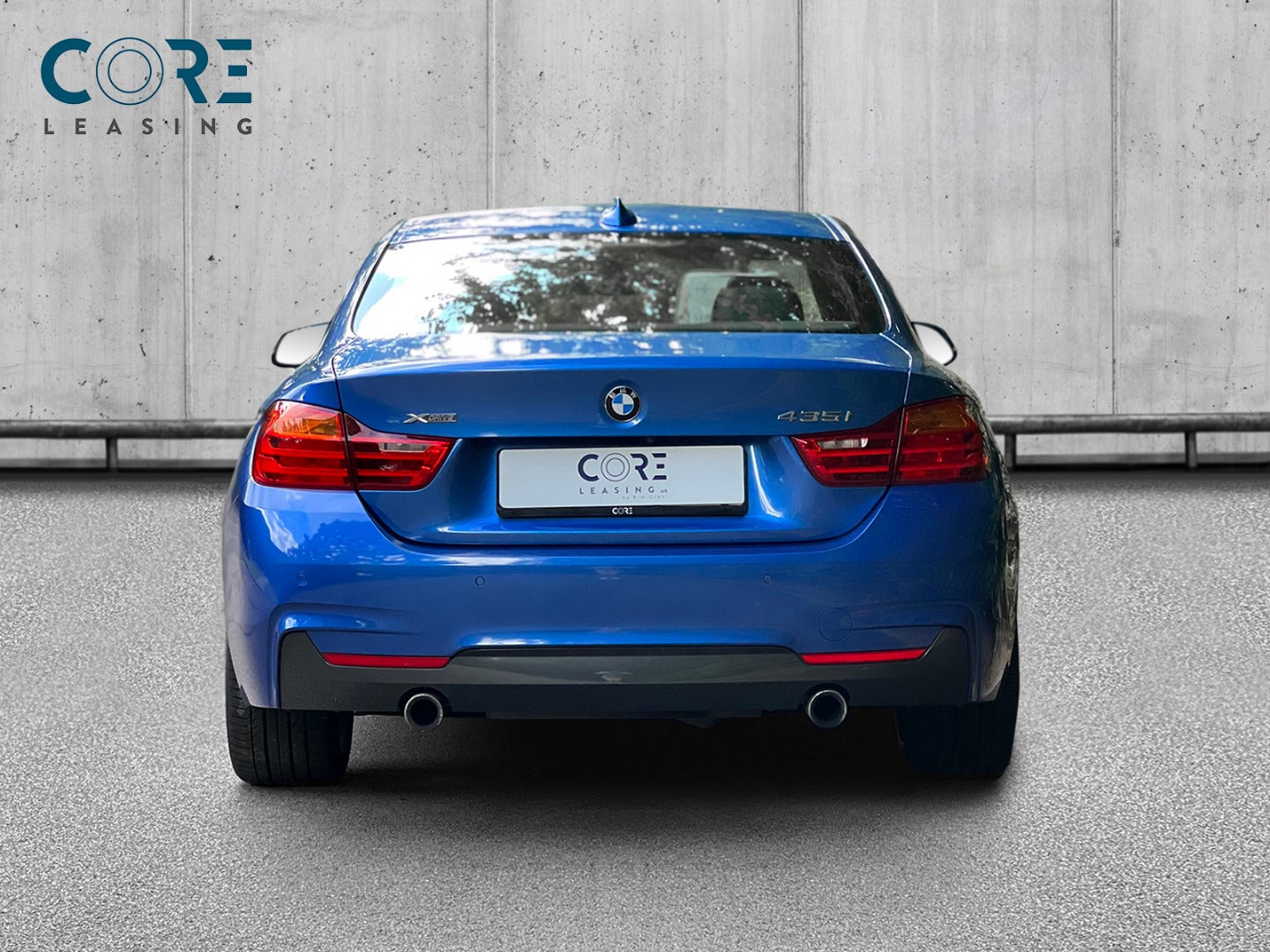 Blåmetal BMW 435i Coupé M-Sport xDrive aut. fra 2015 parkeret foran en betonmur. CORE Leasing A/S er eksperter i BMW leasing.