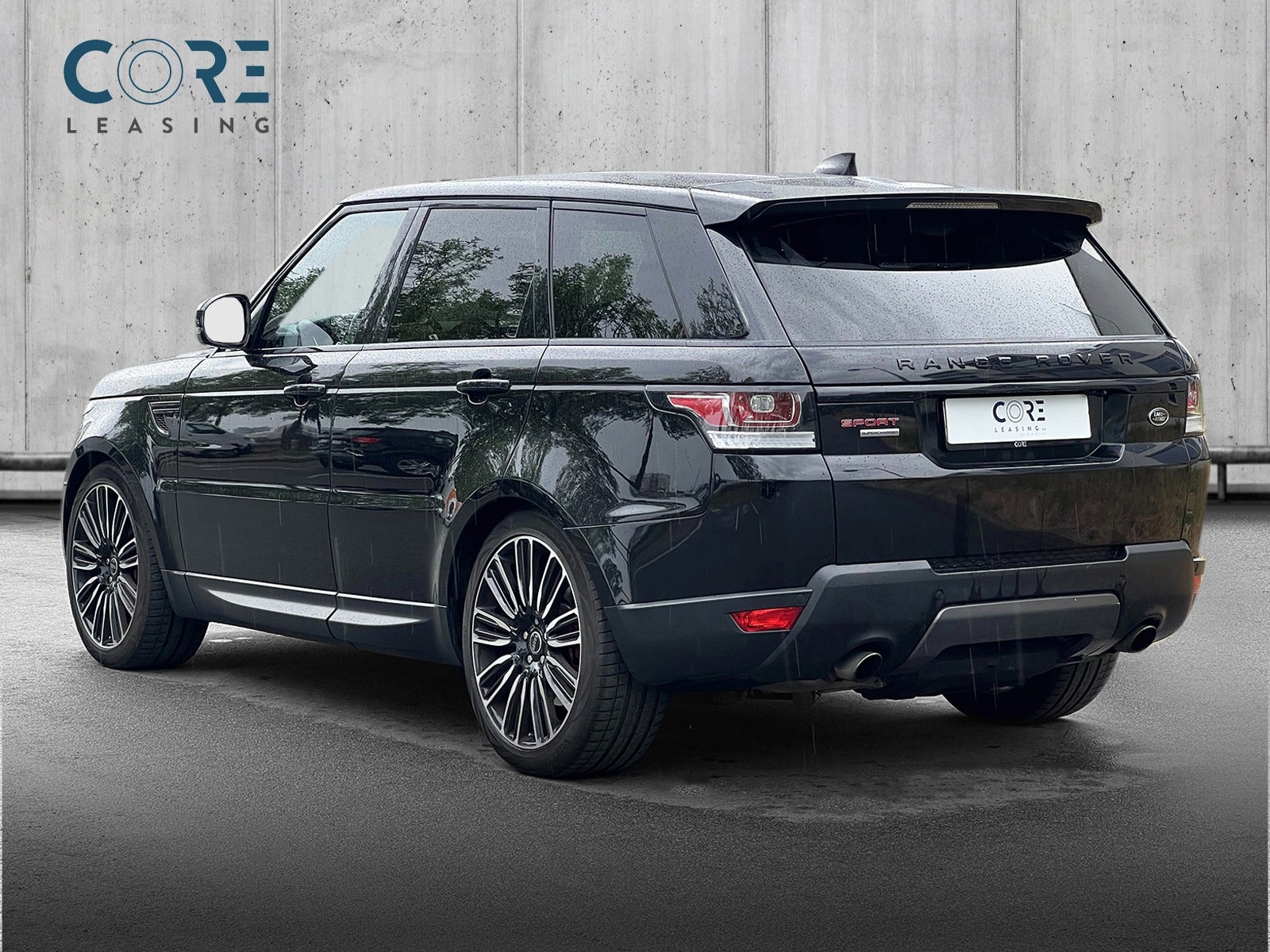 Sortmetal Land Rover Range Rover Sport SCV8 HSE Dynamic aut. fra 2017 parkeret foran en betonmur. CORE Leasing A/S er eksperter i Land Rover leasing.