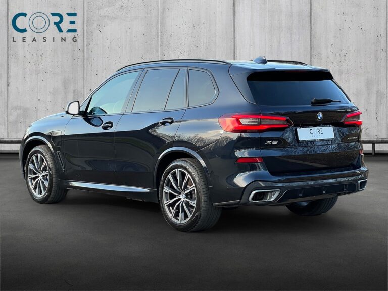 Sortmetal BMW X5 xDrive45e M-Sport aut. fra 2020 parkeret foran en betonmur. CORE Leasing A/S er eksperter i BMW leasing.