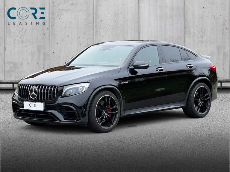Sortmetal Mercedes GLC63 AMG S Coupé aut. 4Matic+ fra 2018 parkeret foran en betonmur. CORE Leasing A/S er eksperter i Mercedes leasing.