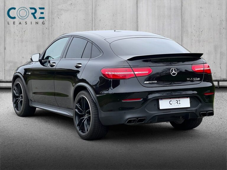 Sortmetal Mercedes GLC63 AMG S Coupé aut. 4Matic+ fra 2018 parkeret foran en betonmur. CORE Leasing A/S er eksperter i Mercedes leasing.