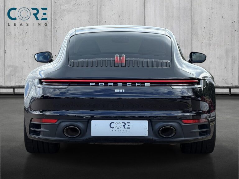 Sortmetal Porsche 911 Carrera S Coupé PDK fra 2019 parkeret foran en betonmur. CORE Leasing A/S er eksperter i Porsche leasing.