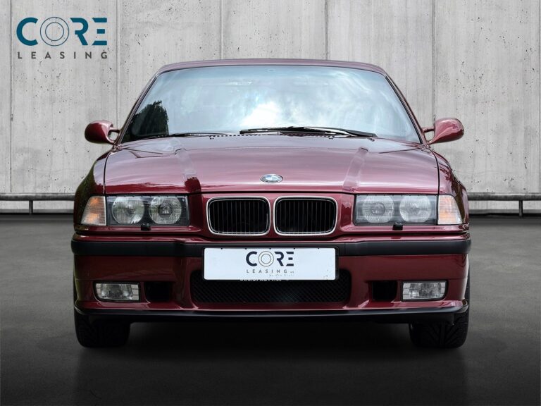 Rødmetal BMW M3 Coupé fra 1996 parkeret foran en betonmur. CORE Leasing A/S er eksperter i BMW leasing.