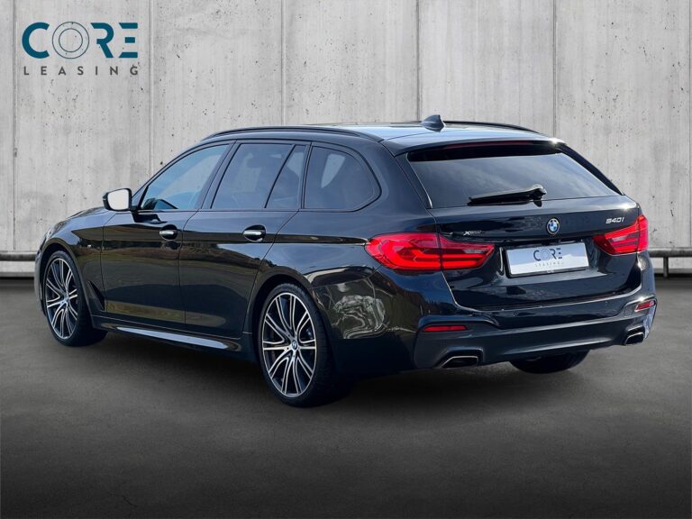 Sortmetal BMW 540i Touring M-Sport xDrive aut. fra 2018 parkeret foran en betonmur. CORE Leasing A/S er eksperter i BMW leasing.