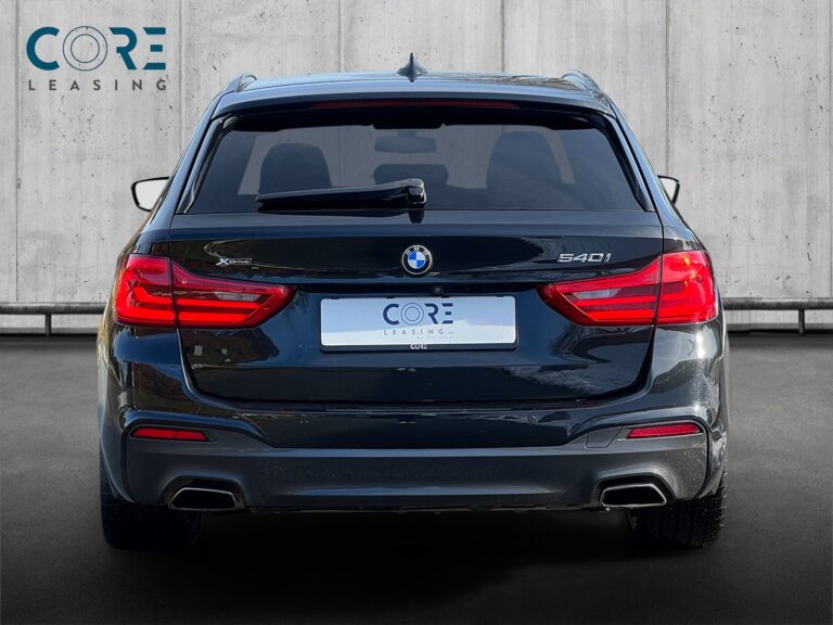 Sortmetal BMW 540i Touring M-Sport xDrive aut. fra 2018 parkeret foran en betonmur. CORE Leasing A/S er eksperter i BMW leasing.