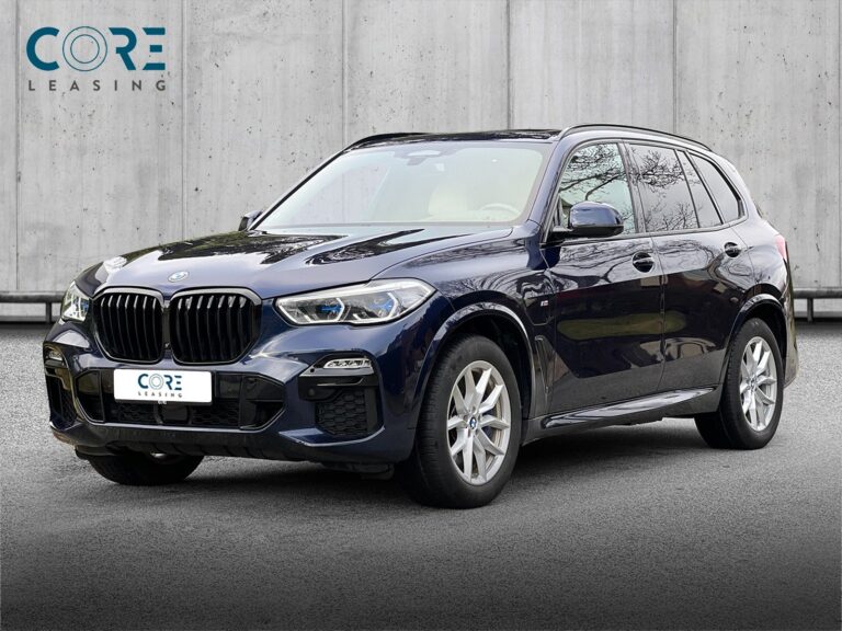 Blåmetal BMW X5 xDrive45e M-Sport aut. fra 2021 parkeret foran en betonmur. CORE Leasing A/S er eksperter i BMW leasing.