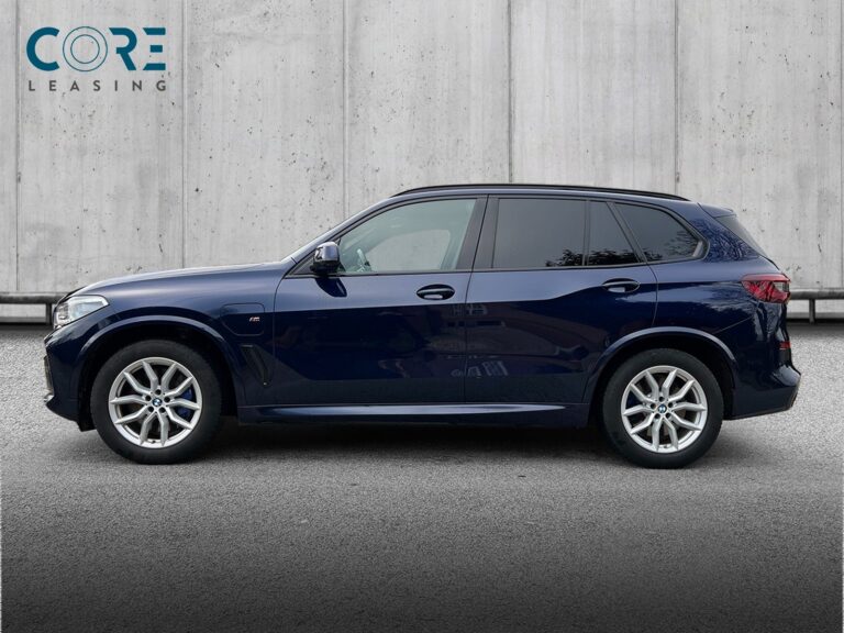 Blåmetal BMW X5 xDrive45e M-Sport aut. fra 2021 parkeret foran en betonmur. CORE Leasing A/S er eksperter i BMW leasing.