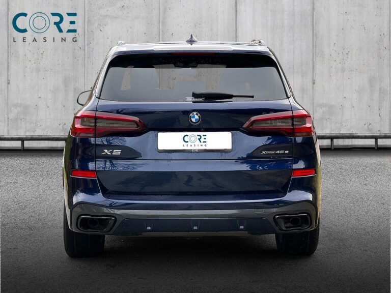 Blåmetal BMW X5 xDrive45e M-Sport aut. fra 2021 parkeret foran en betonmur. CORE Leasing A/S er eksperter i BMW leasing.