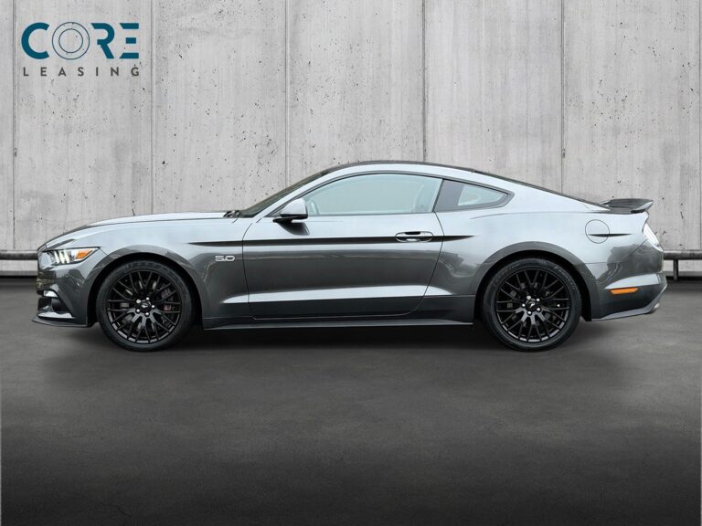 Gråmetal Ford Mustang V8 GT Fastback aut. fra 2015 parkeret foran en betonmur. CORE Leasing A/S er eksperter i Ford leasing.