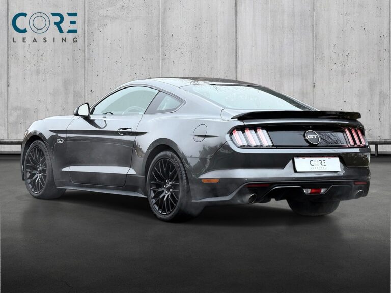 Gråmetal Ford Mustang V8 GT Fastback aut. fra 2015 parkeret foran en betonmur. CORE Leasing A/S er eksperter i Ford leasing.