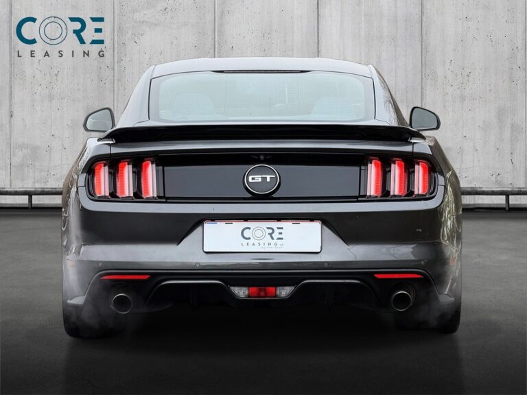 Gråmetal Ford Mustang V8 GT Fastback aut. fra 2015 parkeret foran en betonmur. CORE Leasing A/S er eksperter i Ford leasing.