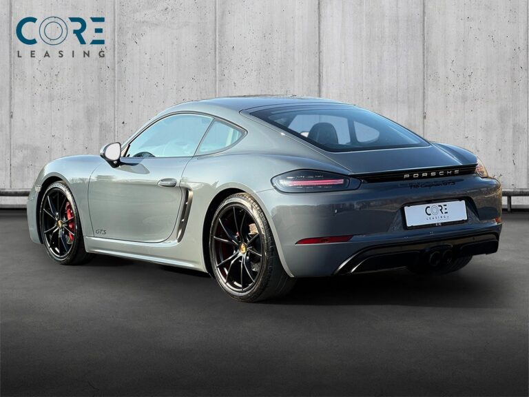 Gråmetal Porsche 718 Cayman GTS PDK fra 2018 parkeret foran en betonmur. CORE Leasing A/S er eksperter i Porsche leasing.