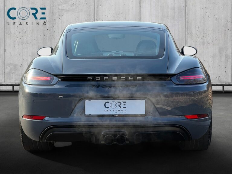 Gråmetal Porsche 718 Cayman GTS PDK fra 2018 parkeret foran en betonmur. CORE Leasing A/S er eksperter i Porsche leasing.