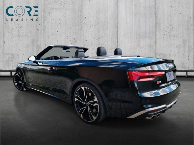 Sortmetal Audi S5 TFSi Cabriolet quattro Tiptr. fra 2022 parkeret foran en betonmur. CORE Leasing A/S er eksperter i Audi leasing.