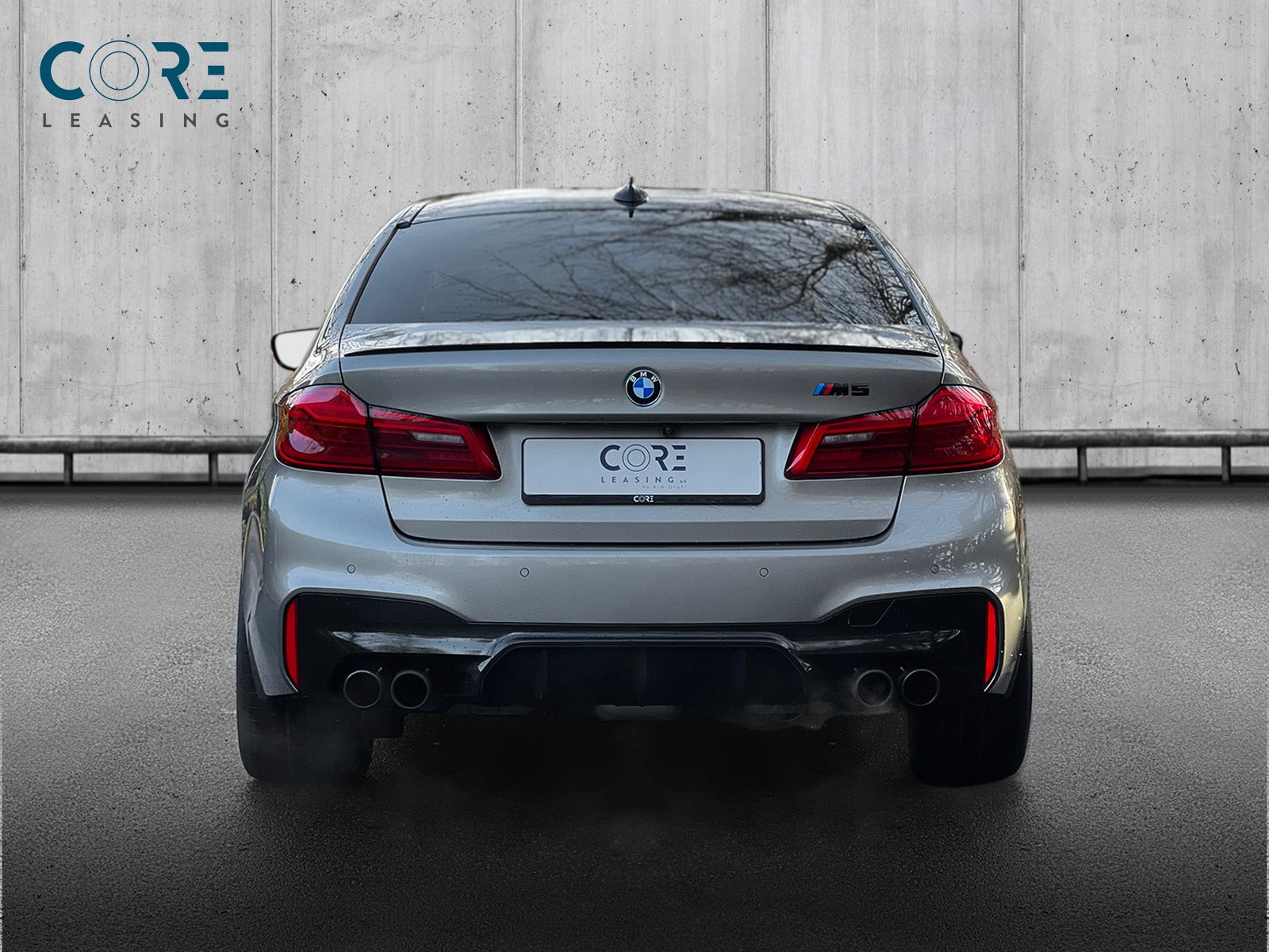 Gråmetal BMW M5 xDrive aut. fra 2018 parkeret foran en betonmur. CORE Leasing A/S er eksperter i BMW leasing.