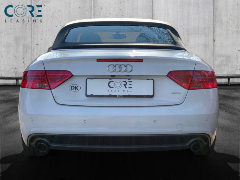 Hvidmetal Audi A5 TFSi Cabriolet quattro S-tr. fra 2015 parkeret foran en betonmur. CORE Leasing A/S er eksperter i Audi leasing.