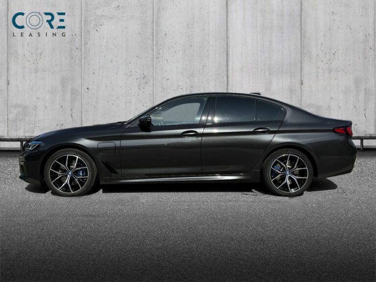 Gråmetal BMW 545e M-Sport xDrive aut. fra 2022 parkeret foran en betonmur. CORE Leasing A/S er eksperter i BMW leasing.
