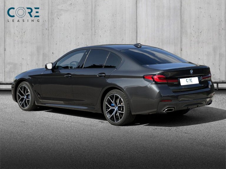 Gråmetal BMW 545e M-Sport xDrive aut. fra 2022 parkeret foran en betonmur. CORE Leasing A/S er eksperter i BMW leasing.
