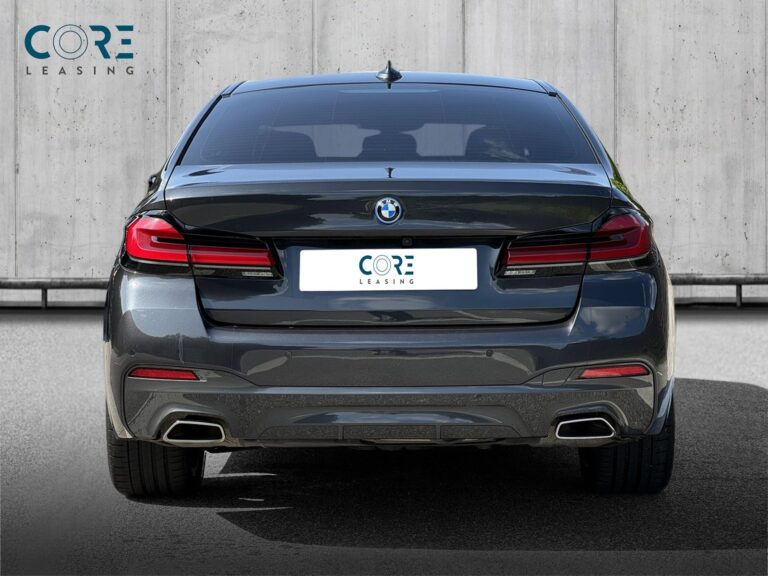 Gråmetal BMW 545e M-Sport xDrive aut. fra 2022 parkeret foran en betonmur. CORE Leasing A/S er eksperter i BMW leasing.
